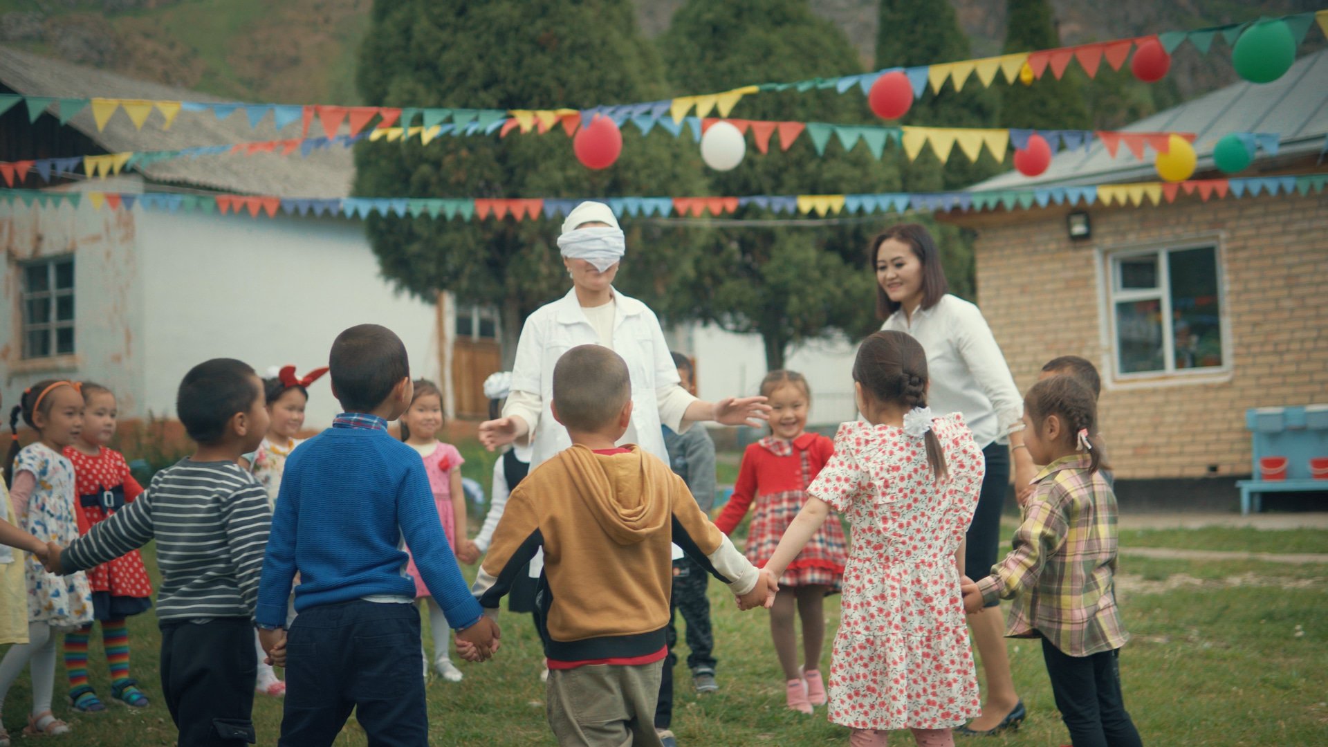 Photo of Gulbarak outside of the classroom teaching children.